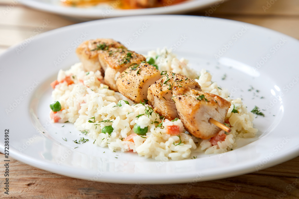 chicken kebab with rice and vegetables on the wooden background chicken kebab with rice and vegetables on the wooden background