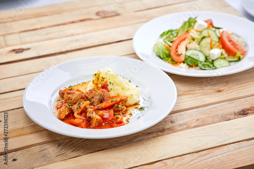 chicken with mashed potatoes and salad on the wooden background