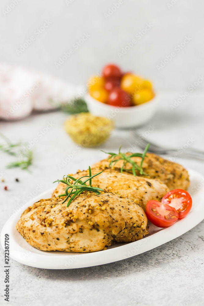 Baked mustard honey chicken breasts with cherry tomatoes. Selective focus, space for text.