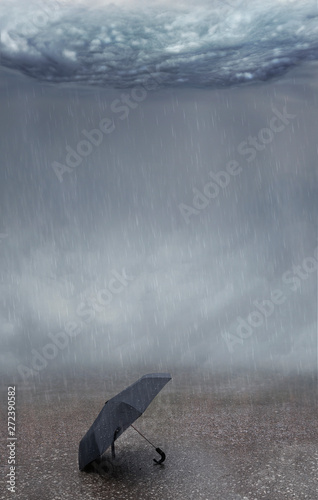 Background and pattern with rain and thunderstorm. Umbrella lies in the middle of the wet street