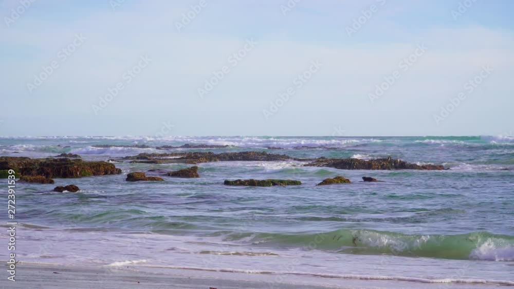 Sea waves, rocks and sandy beach on sunny afternoon. Sea waves, rocks and sandy beach on sunny afternoon.