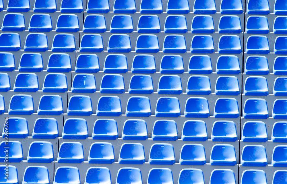 Fototapeta premium Empty blue plastic chairs in a row at the football stadium