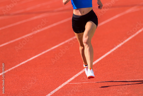 Young sporty woman running on sunny day
