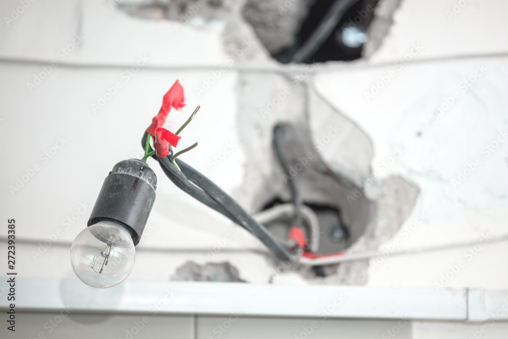 bad wiring. electrical wires protrude from the wall. live lamp.