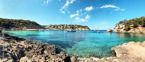 Nice crystal clear blue water of a lovely beach view with boats and turquoise summer color tones. Cala Portals Vells, Mallorca. Balearic Islands photo