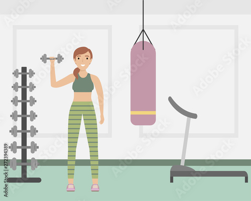 Girl in uniform with dumbbells in the fitness club. Fitness classes.