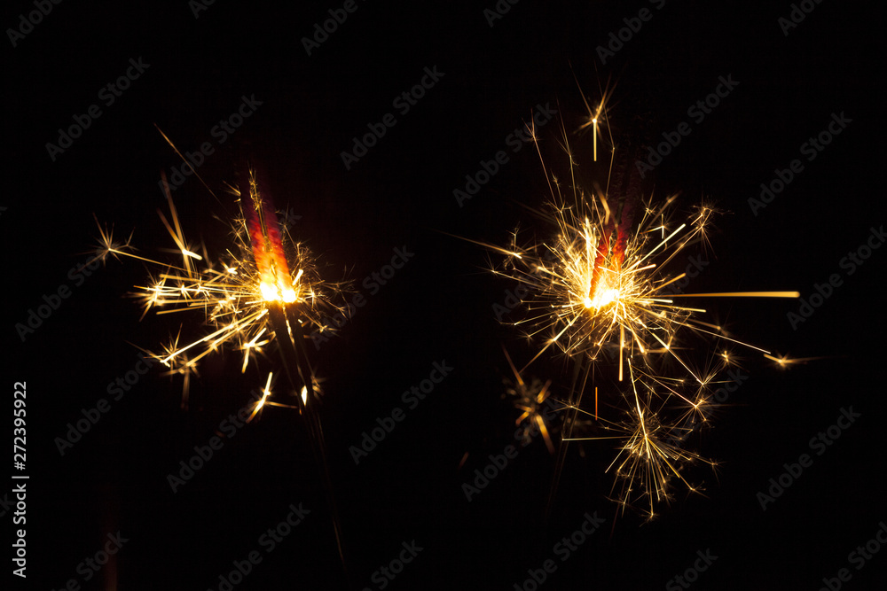 Dark background with two sparklers Dark background with two sparklers