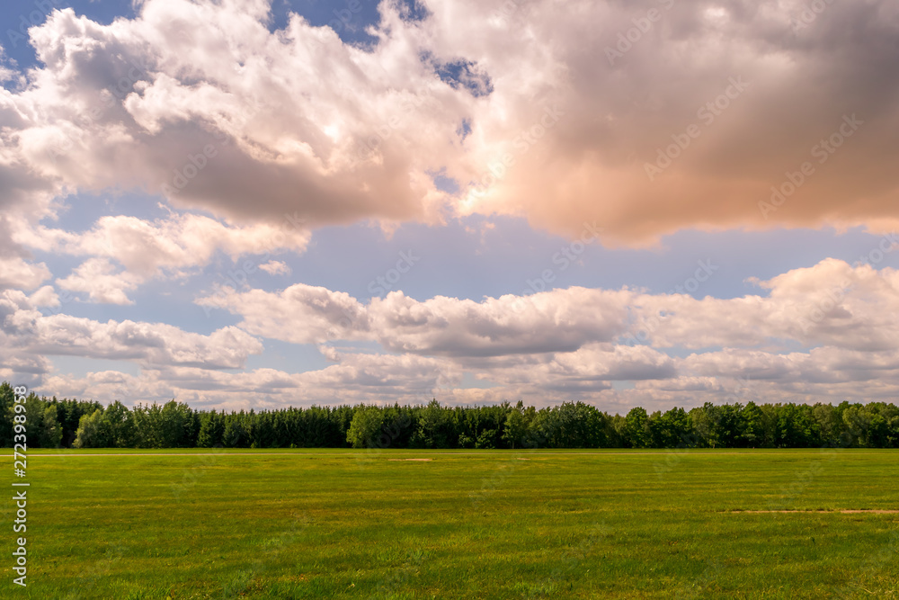 Pink clouds at sunset over a agricultural field