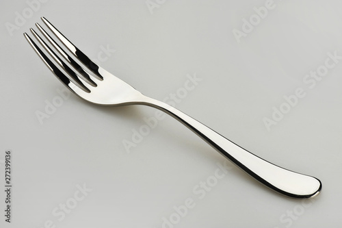 One dining fork resting on a gray surface