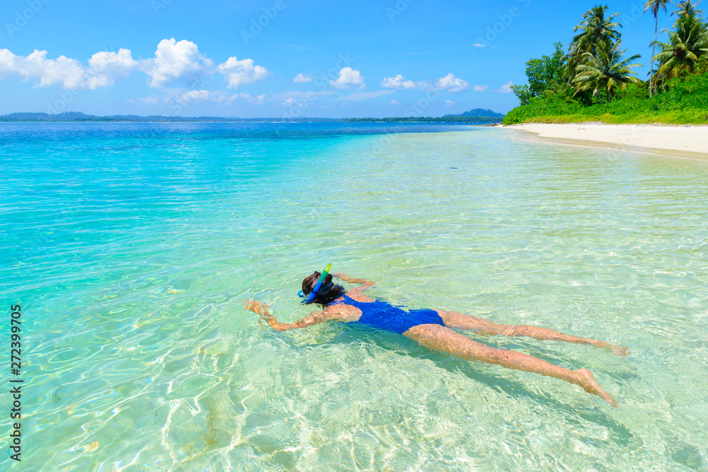 Woman snorkeling in caribbean sea, turquoise blue water, tropical island. Indonesia Banyak Islands Sumatra, tourist diving travel destination.