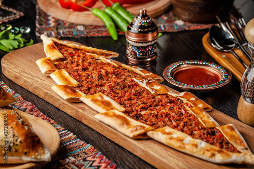 Traditional Turkish cuisine. Turkish pizza Pita with meat. Turk Pidesi or  Sucuk Pide. Beautiful serving dishes in the restaurant. Background image. copy space photo