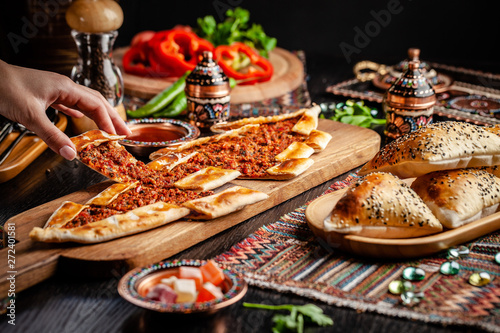 Traditional Turkish cuisine. Turkish pizza Pita with meat. Turk Pidesi or  Sucuk Pide. Beautiful serving dishes in the restaurant. Background image. copy space photo