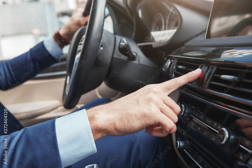 My favourite song. Cropped image of businessman in full suit pushing on the button of air regulator in the car