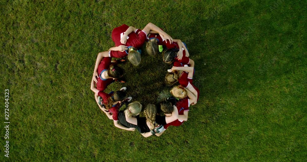 OVERHEAD CRANE Teenager kid girls soccer players huddling up before game, cheering each other. 4K UHD 60 FPS SLO MO