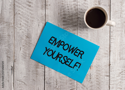 Text sign showing Empower Yourself. Business photo showcasing taking control of our life setting goals and making choices Pastel Colour paper placed next to a cup of coffee above the wooden table