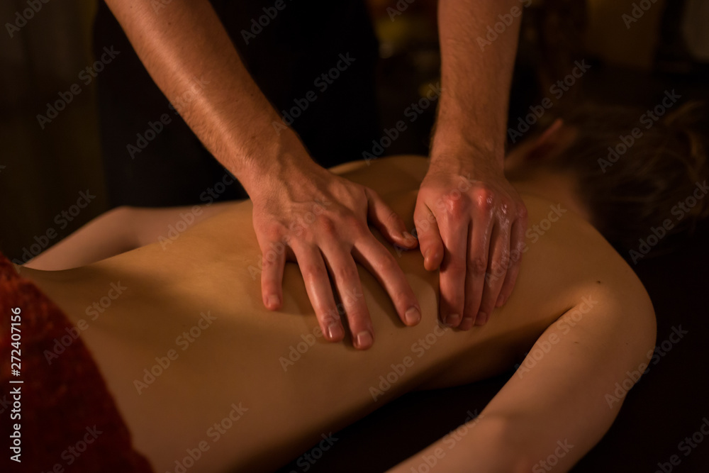 Masseur hands doing massage in spa center