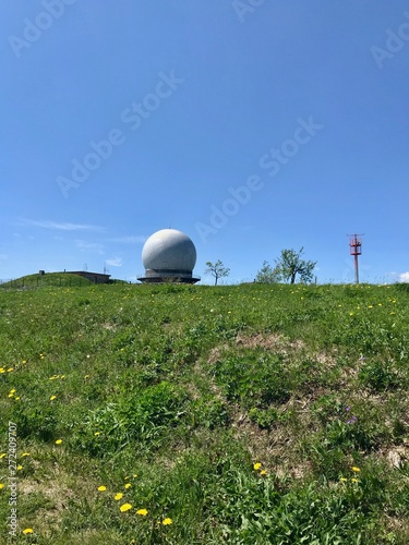 Scenic summer hike to the Wasserkuppe, the highest mountain of the Rhoen (Germany) & its Radom (radar station during cold War) through lush green nature landscape with a bright blue sky & white clouds