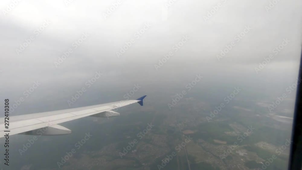 The view from the window of an airplane rising above the clouds in the bright clouds The view from the window of an airplane rising above the clouds in the bright clouds