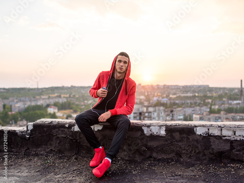 Manly but romantic sport man taking a smartphone or mobile phone photo or picture of sunset on a city rooftop after training photo