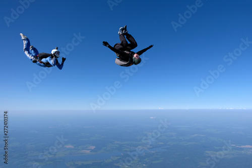 Skydiving. An instructor trains a student to fly.