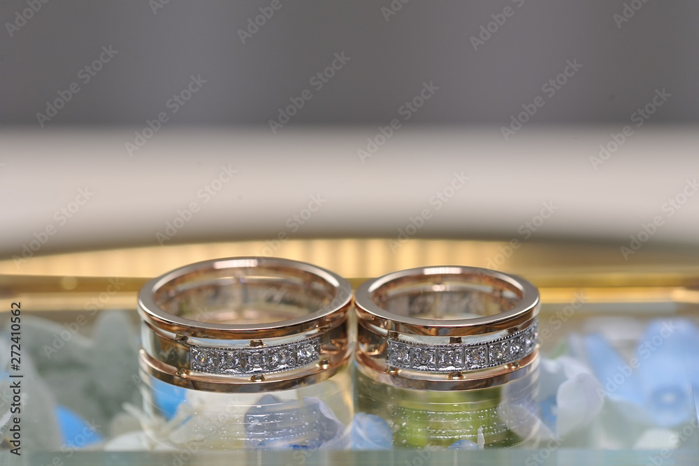 Wedding diamond rings on a glass surface with reflection. Very close up macro photography. Wedding diamond rings on a glass surface with reflection. Very close up macro photography.