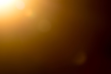Lens flare and light beam on dark background yellow color, photo from lens camera