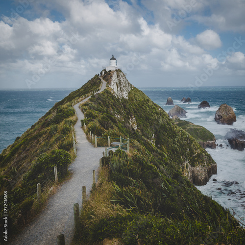 Nugget Point lighthouse trail and rocks in the ocean in Otago, New Zealand