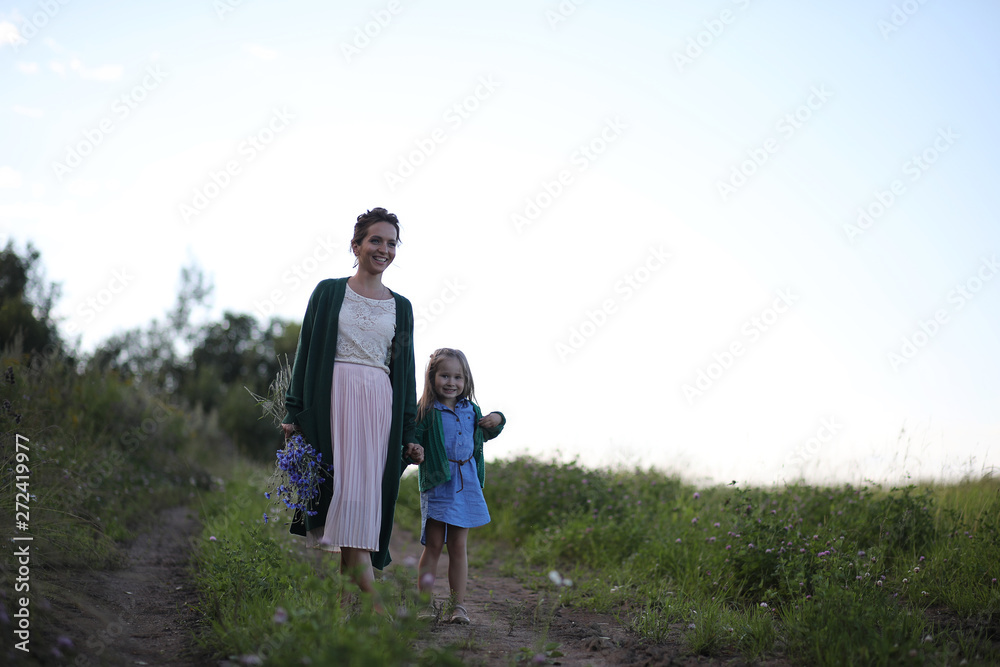 Mother with daughter walking on a road