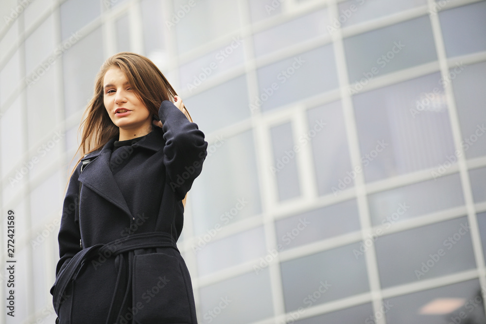 Beautiful girl in a coat in business downtown