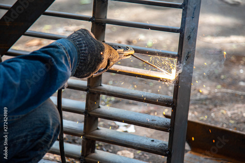 A worker welding metal Drain cap.