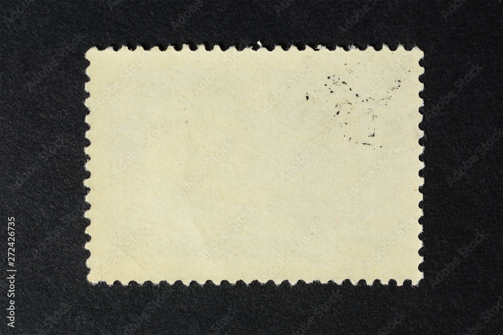 Blank vintage postage stamp on black background. Mockup with perforations for your picture text or design.