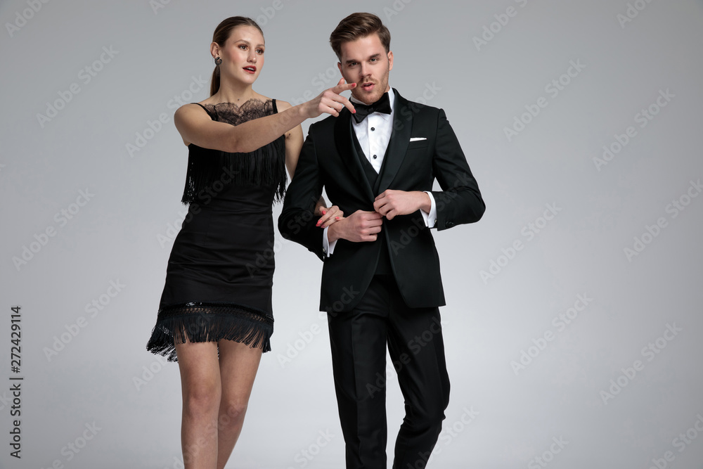 Attractive girlfriend pointing while walking forward with his boyfriend