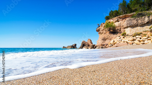 Beautiful deserted beach and huge rocks on the background. Miami Platja, Costa Dorada Coast, Tarragona, Spain