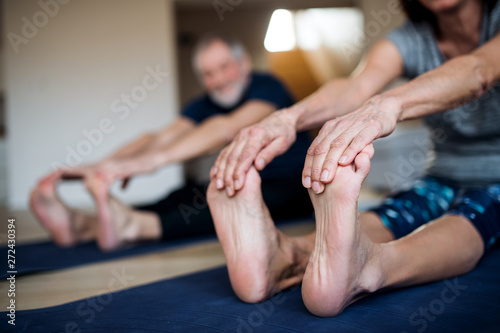 Fotografie A midsection of senior couple indoors at home, doing exercise on the floor