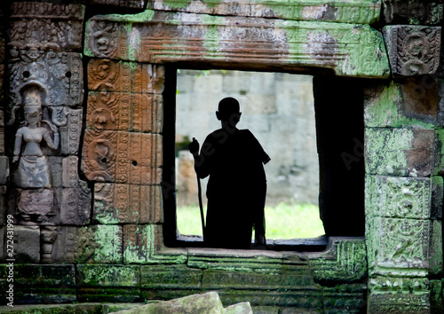 Monk silhouette standing in a temple vestige in Angkor wat, Siem Reap Province, Angkor, Cambodia