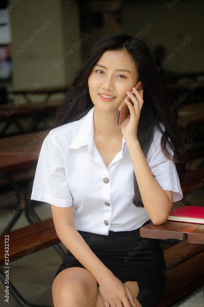 Portrait of thai adult student university uniform beautiful girl calling smart phone Portrait of thai adult student university uniform beautiful girl calling smart phone