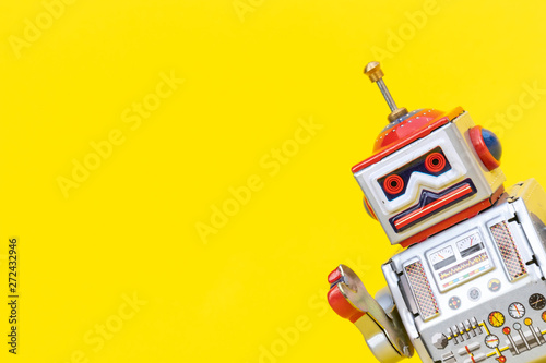 Antique tin toy robot on yellow background. Vintage and classic concept free copy space for text.