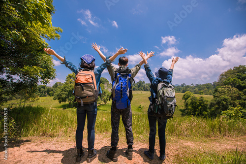 Asian Group of young people with friends backpacks walking together and happy friends are raised arms and enjoying a beautiful nature and cheering ,Relax time on holiday concept travel
