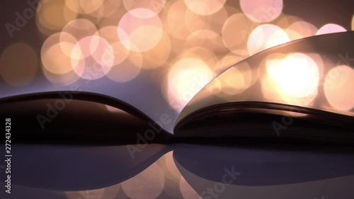 flipping and opening the book page on colorful light blurred bokeh for education, reading, knowledge, fiction, fairy concept background
