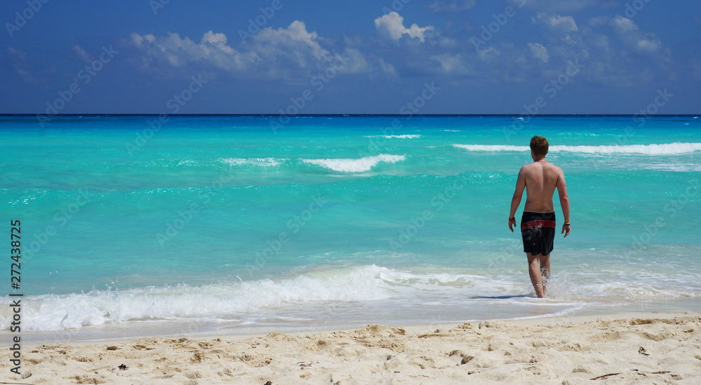 Man going to swim in Caribbean sea, Cancun beach, Mexico. Man going to swim in Caribbean sea, Cancun beach, Mexico.