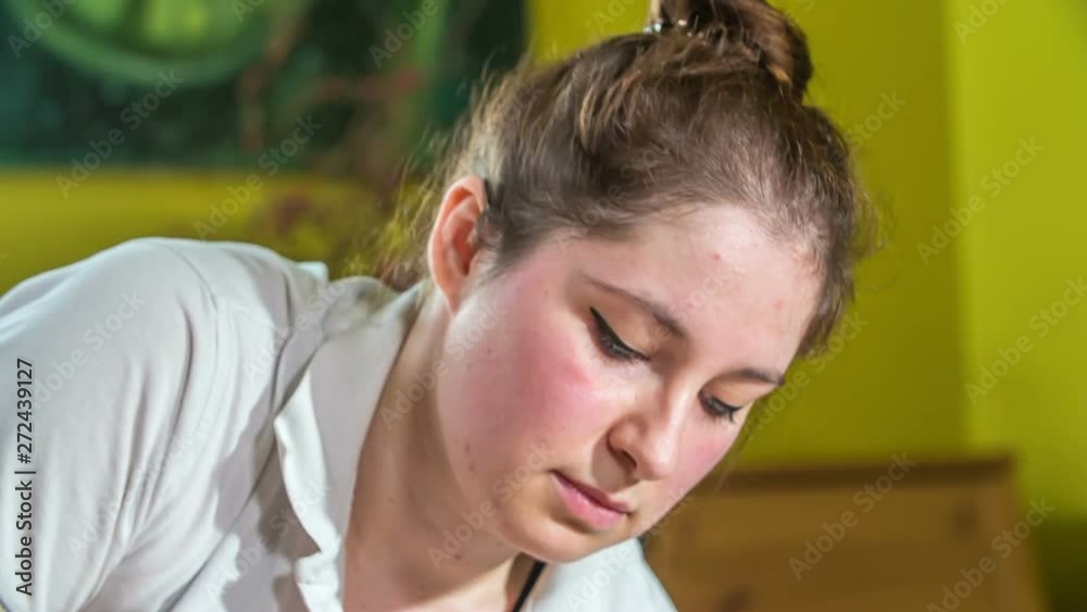 A young masseur during her work. She looks focused. A young masseur during her work. She looks focused.