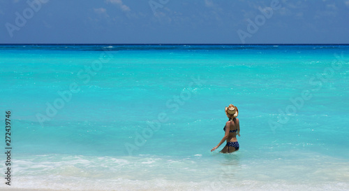 Woman swimming in Caribbean sea with a beautiful turquoise color. Vacation in Cancun, Mexico.