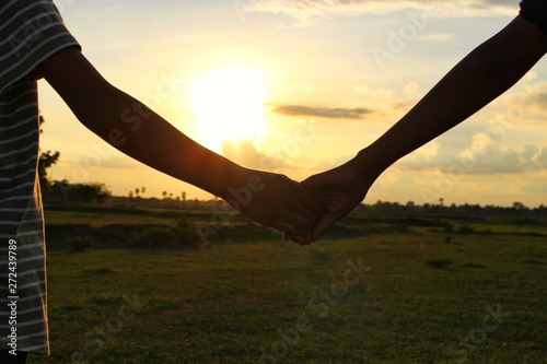 Children hold hands to show friendship, shoot blurred images, golden yellow light in the evening