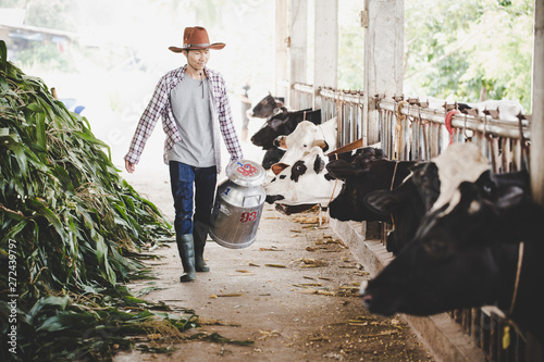Portrait of a handsome milkman walking with milk container outdoors on the rural scene background