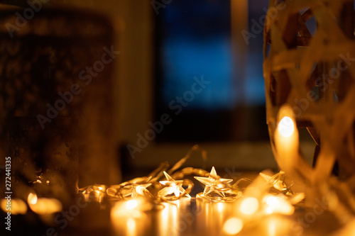 Light chain and candles create a cosy atmosphere. Romantic. Christmas. photo