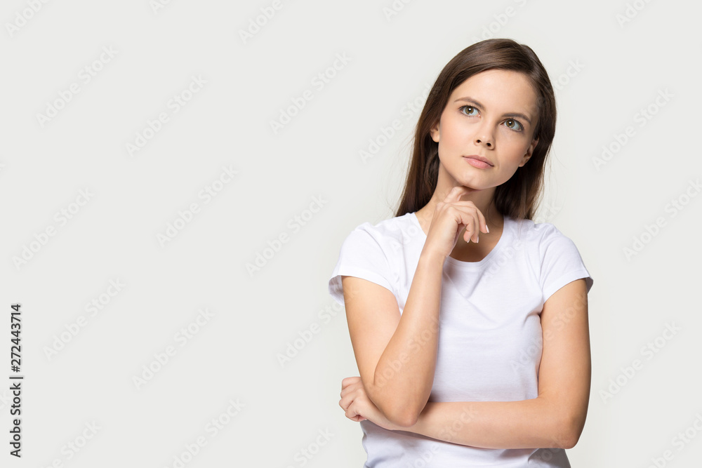 Pensive young caucasian woman thinking isolated on studio grey background Pensive young caucasian woman thinking isolated on studio grey background