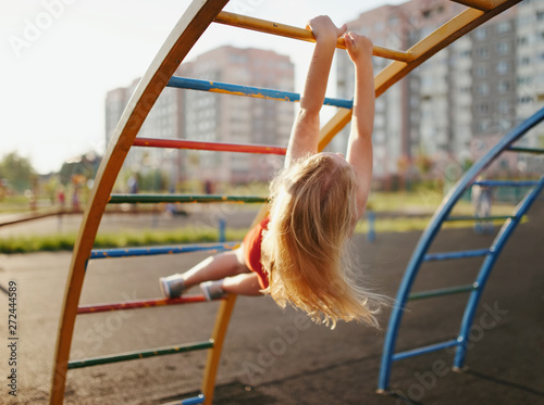 Fotografie little girl has fun on monkey bar