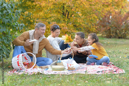 Portrait of family having a picnic in the park in autumn