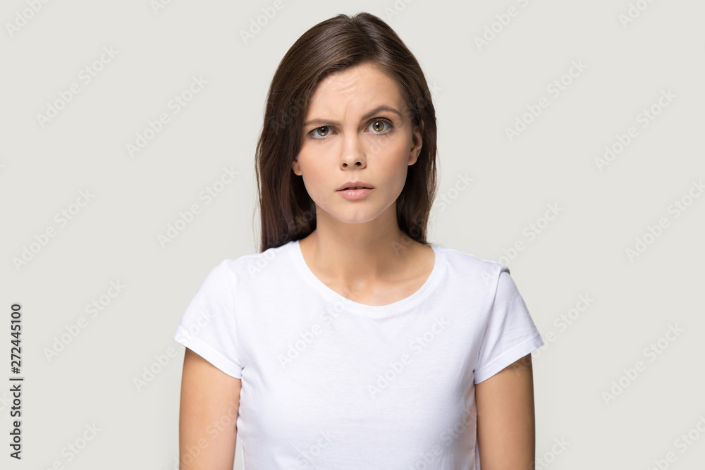 Sceptic suspicious millennial woman pose on grey studio background Sceptic suspicious millennial woman pose on grey studio background