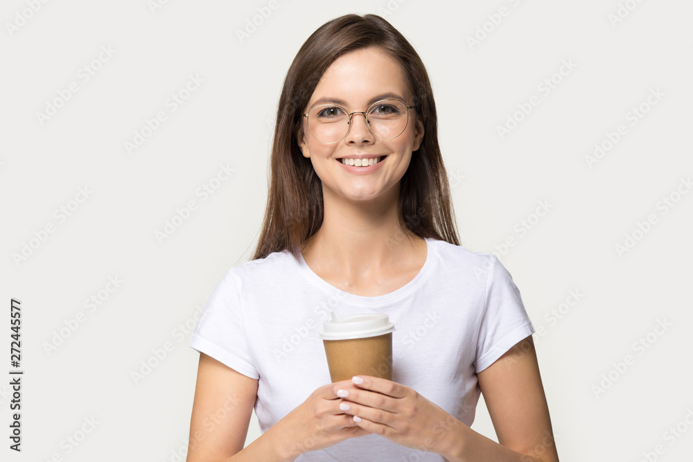 Attractive girl holding coffee cup pose over grey studio background Attractive girl holding coffee cup pose over grey studio background